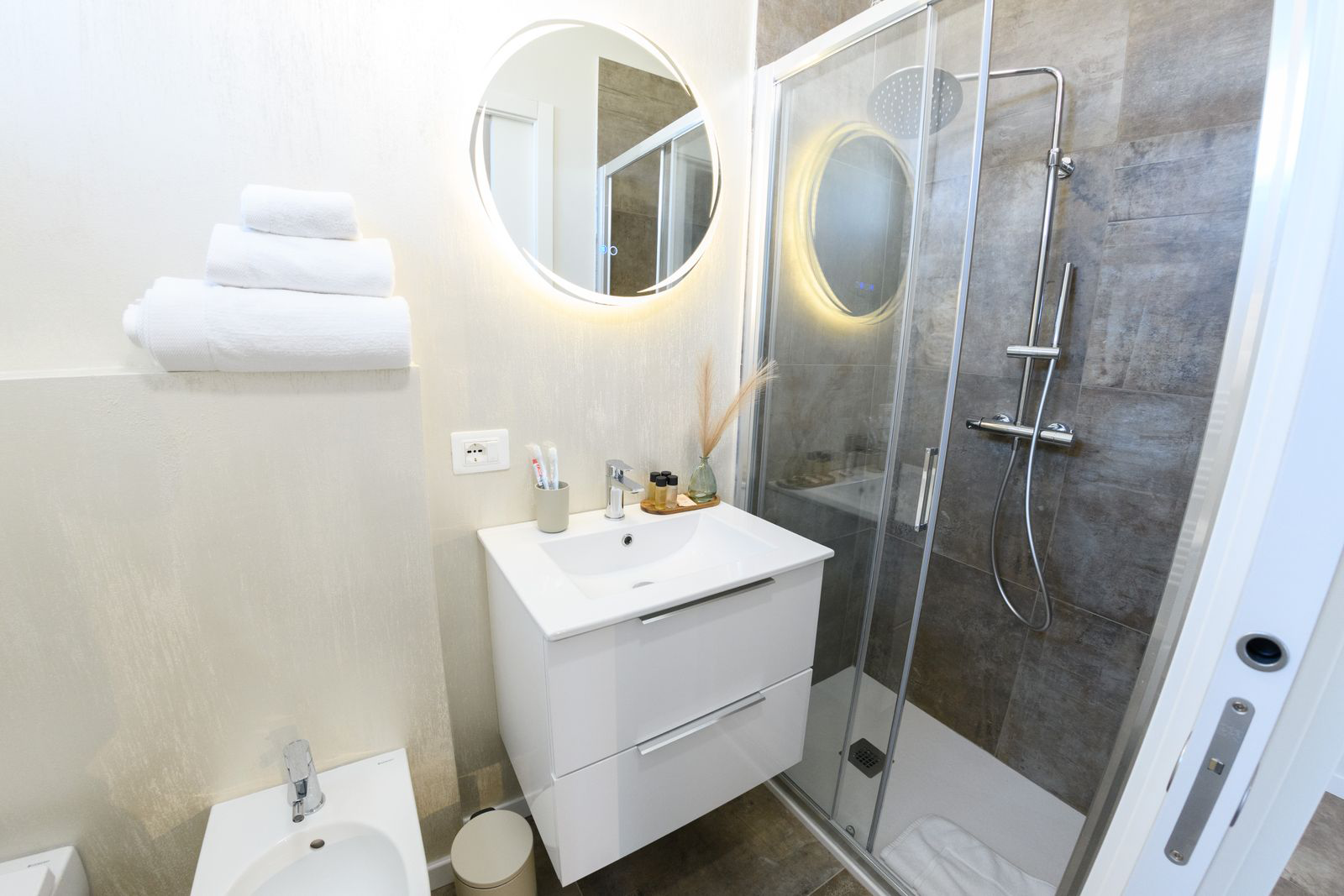 Bagno con doccia e specchio a rotondo